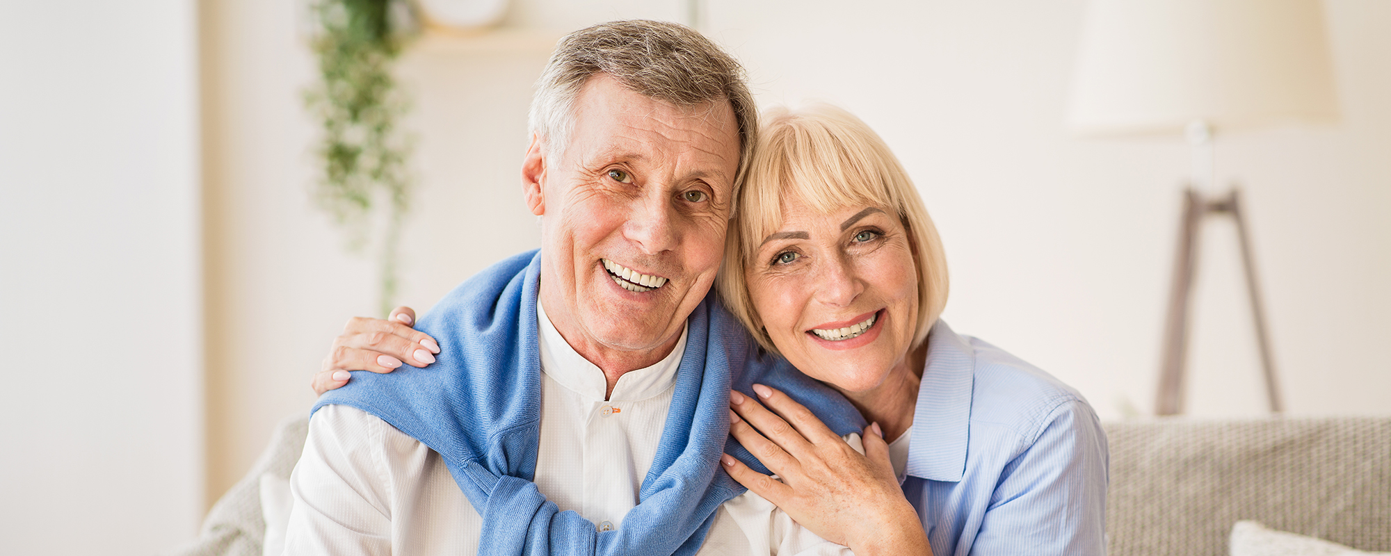 Excited mature couple with digital tablet smiling to camera
